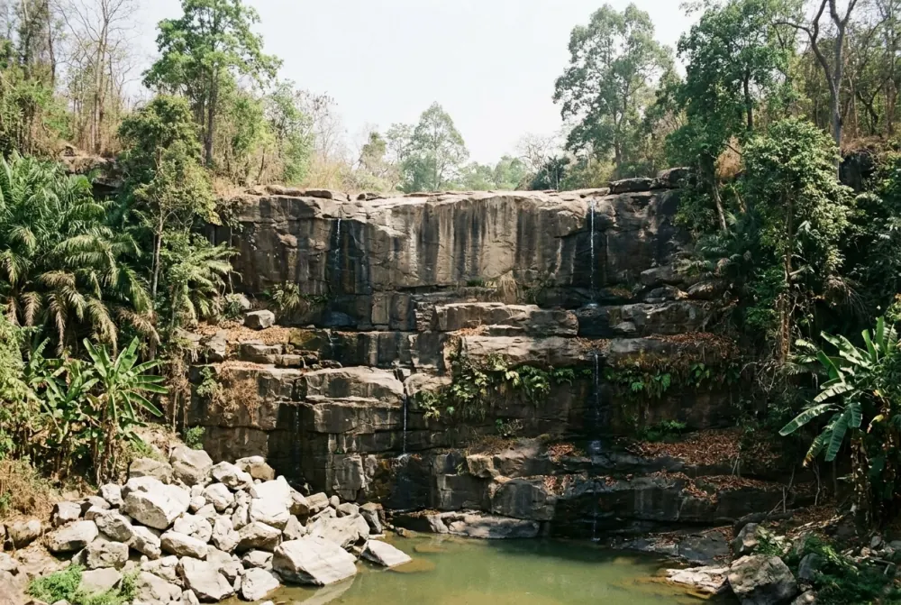 The same kind of waterfall reduced to thin trickles over exposed rock in the dry season